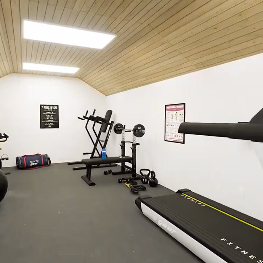 A treadmill inside a Shedquarters shed converted into a home gym