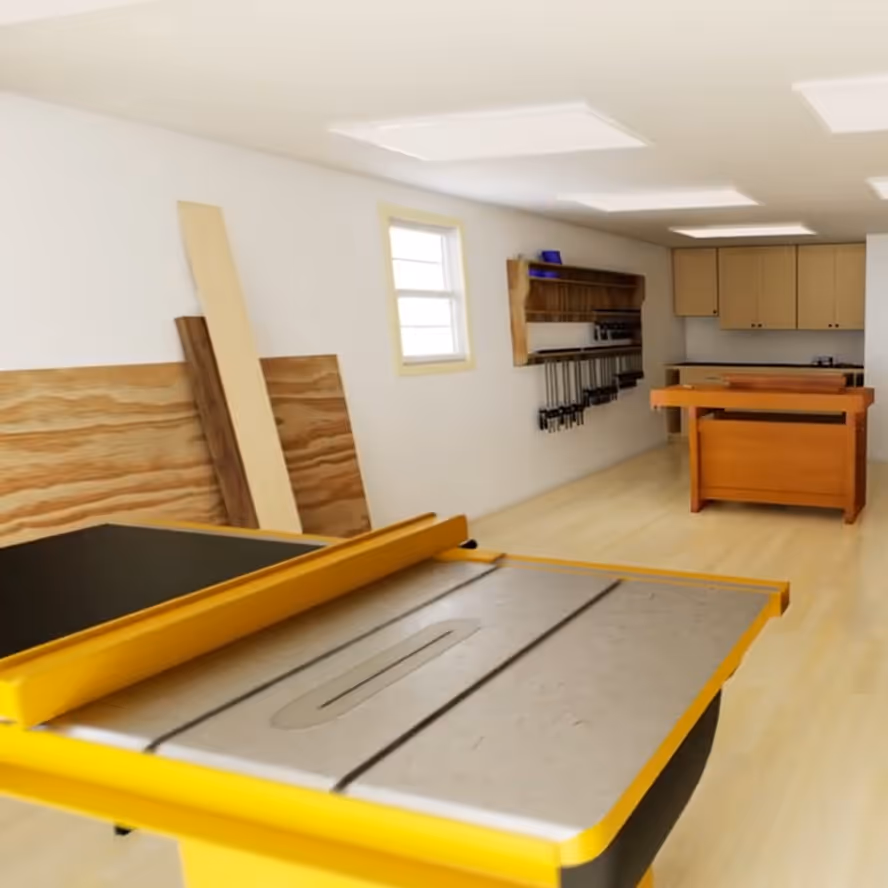 A workbench and tool wall inside a Handcrafted Homestead shed used as a wood shop